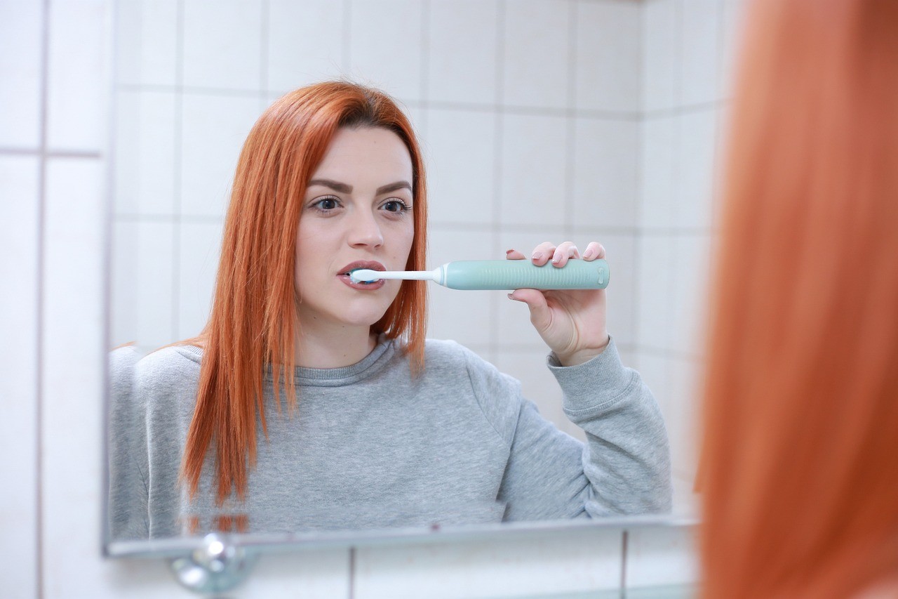 woman brushing teeth at home 